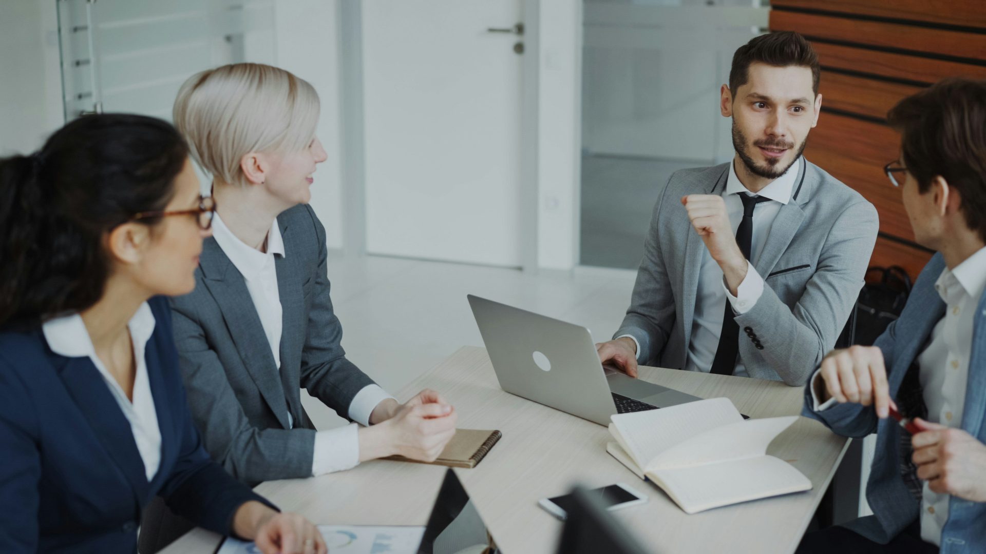 Quatre professionnels réunis autour d'une table pour une réunion d'affaires.