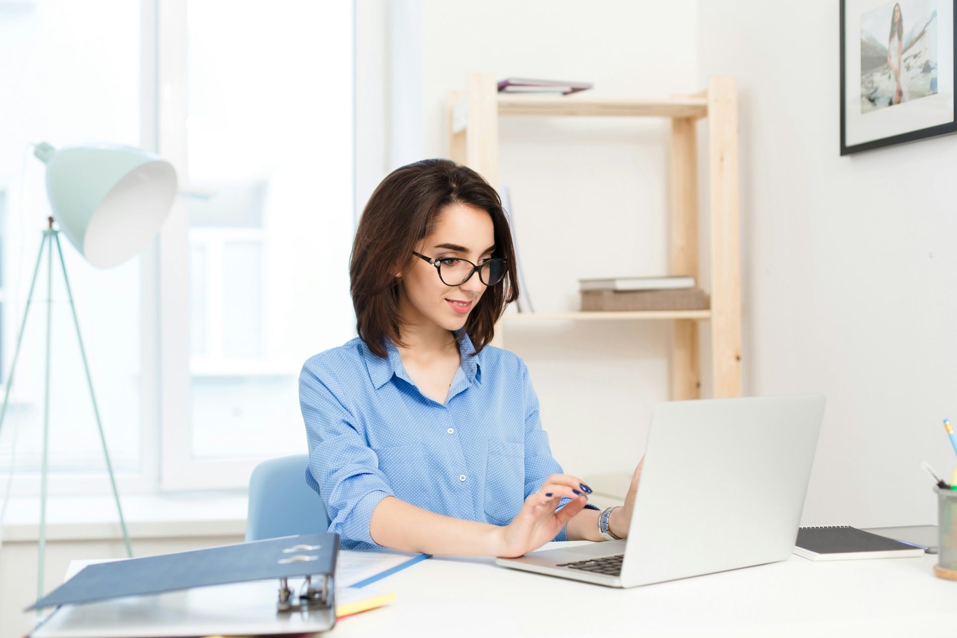 une femme assise à un bureau travaillant sur un ordinateur portable