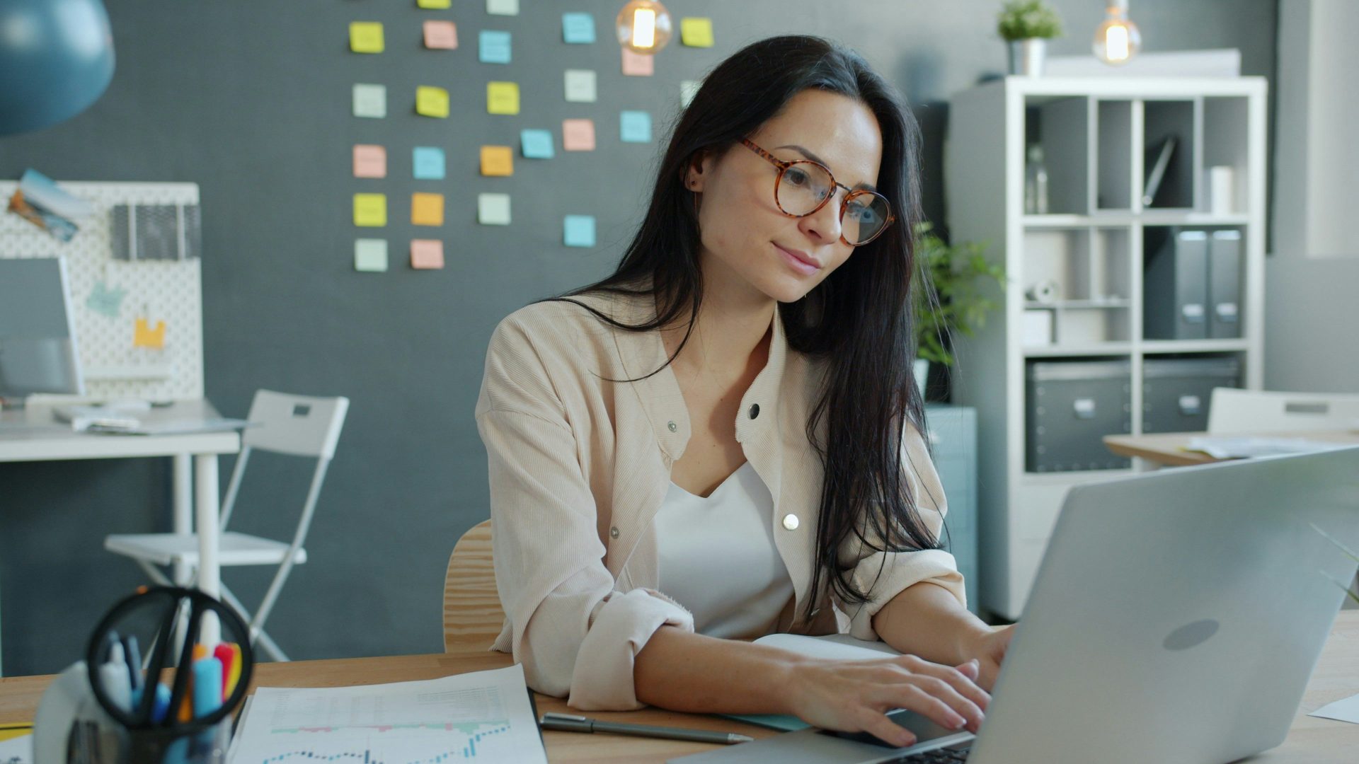 Jeune femme travaillant sur un ordinateur portable dans un bureau moderne.